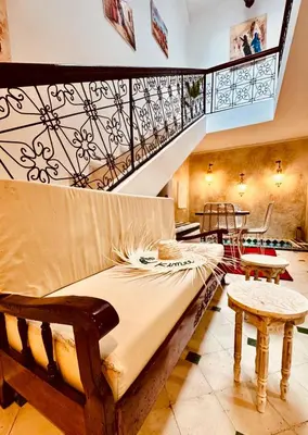 a bed in a room with a staircase and tables at Riad Kimee Room 4 in Marrakech