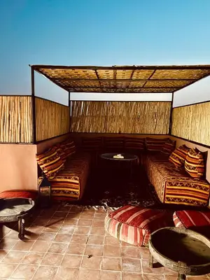 a room with two beds and a table and chairs at Riad Kimee Room 4 in Marrakech