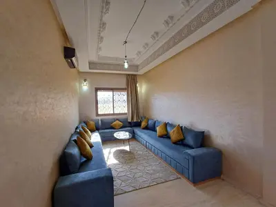 a living room with blue couches and a window at Villa Targa in Marrakech