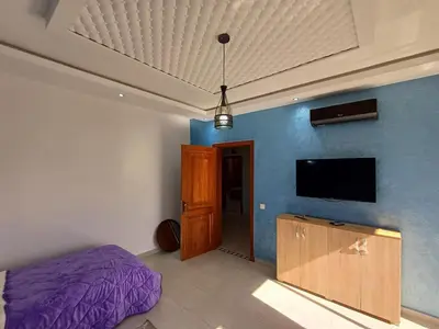 a bedroom with a bed and a flat screen tv at Villa Targa in Marrakech