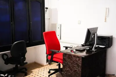 an office with a desk with a computer and a red chair at Riad Mounir in Marrakech