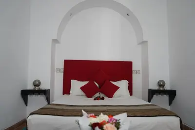 a bedroom with a large bed with a red headboard at Riad Mounir in Marrakech