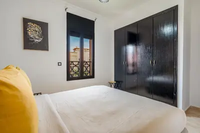 a bedroom with a large white bed and black cabinets at Villa Palmera - 6 people - Pool - Marrakech in Marrakech