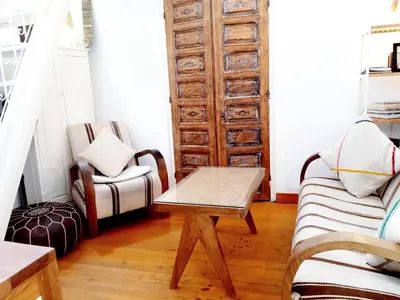 a living room with a table and a chair at Ma petite maison cosy en medina in Marrakech
