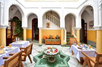 a restaurant with tables and a couch in a room at RIAD Zina Rose 89 in Marrakech