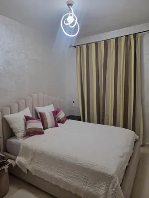 a bedroom with a large white bed with pillows at appartement mabrouka in Marrakech