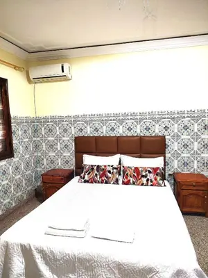 a bedroom with a bed with a white bedspread at Maison traditionnelle marocaine à Marrakech in Marrakech