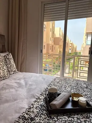 a tray of food on a bed with a window at Charmant appartement familial in Marrakech