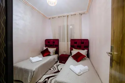 two beds with red pillows in a room at Charming and quiet apartment 1 in Marrakech