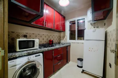 a kitchen with a washing machine and a microwave at Charming and quiet apartment 1 in Marrakech