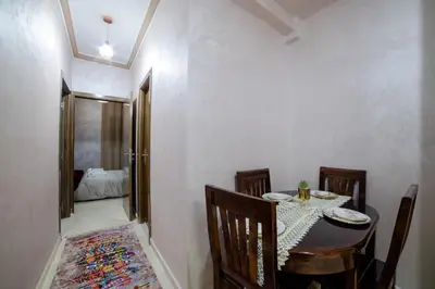 a dining room with a table and chairs and a mirror at Charming and quiet apartment 1 in Marrakech