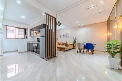 a living room with a kitchen and a dining room at Appartement cosy moderne piscine in Marrakech