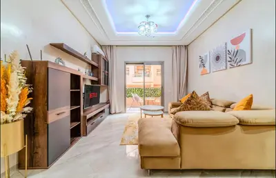 a living room with a couch and a table at Appartement cosy moderne piscine in Marrakech