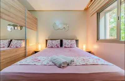 a bedroom with a large bed with pink sheets at Appartement cosy moderne piscine in Marrakech