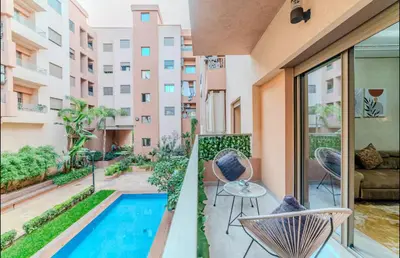 an apartment balcony with a swimming pool and a patio at Appartement cosy moderne piscine in Marrakech