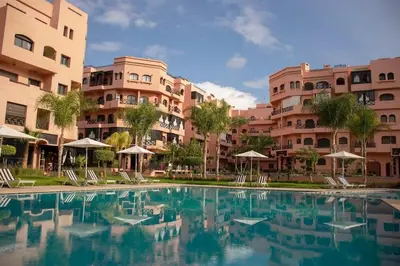 a swimming pool in front of some apartment buildings at The Medina Touch - Marrakech in Marrakech