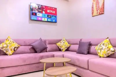 a purple couch with pillows and a table and a tv at Residence Jnan Atlas gueliz in Marrakech