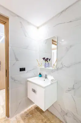 a white bathroom with a sink and a mirror at Stylish modern 1BR in gueliz in Marrakech