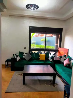 a living room with a green couch and a table at marrakech premium village c18 in Marrakech