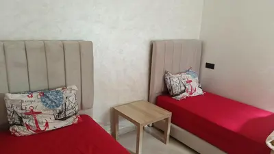a small room with two beds and a table at marrakech premium village c18 in Marrakech