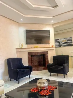 a living room with two chairs and a fireplace at Apartment with pool in Guéliz Hadika al koubra in Marrakech