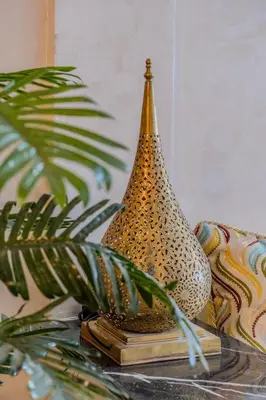 a vase sitting on a table next to a plant at Chic & spacious apartment in Gueliz in Marrakech