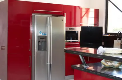 a stainless steel refrigerator in a kitchen with red cabinets at Domaine Marradise in Marrakech