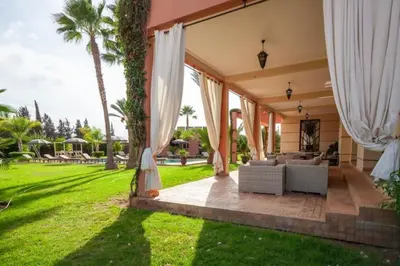 an exterior view of a house with white curtains at Domaine Marradise in Marrakech