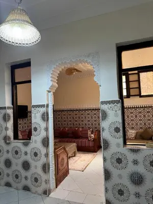 a living room with a couch and two mirrors at Logment cosy in Marrakech
