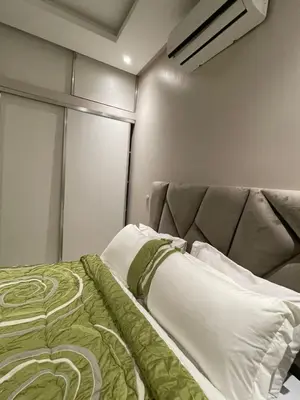 a bedroom with a bed with a green blanket at Appartement moderne dans Marrakech in Marrakech