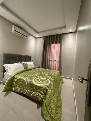 a bedroom with a bed with a green blanket at Appartement moderne dans Marrakech in Marrakech