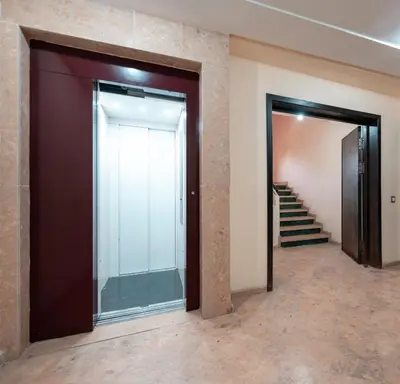 a hallway with two doors and stairs in a building at La maison du soleil in Oulad Akkou
