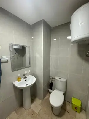 a bathroom with a white toilet and a sink at Bright & comfortable apartment in Marrakech