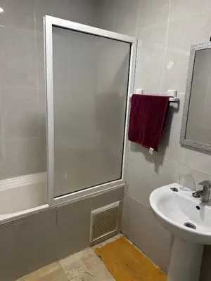 a bathroom with a shower and a sink and a mirror at Bright & comfortable apartment in Marrakech
