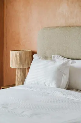 a bed with white sheets and pillows and a lamp at Dar Saada Private Villa in Marrakech