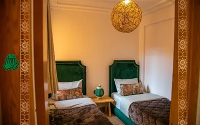 a bedroom with two beds and a chandelier at Cozy, Nice appartement,swimming pool,Wifi in Marrakech