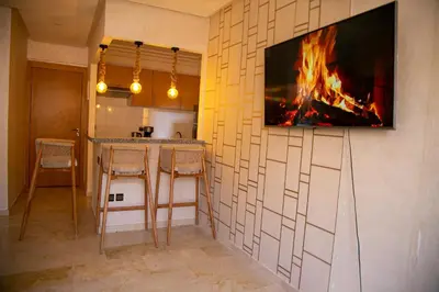 a kitchen with a fireplace and a tv on the wall at Cozy, Nice appartement,swimming pool,Wifi in Marrakech