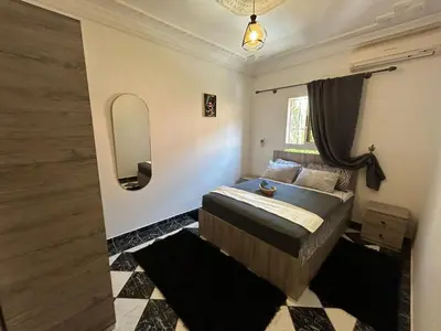 a bedroom with a bed and a mirror and a window at Apartment A Zaitone G5 N3 in Marrakech