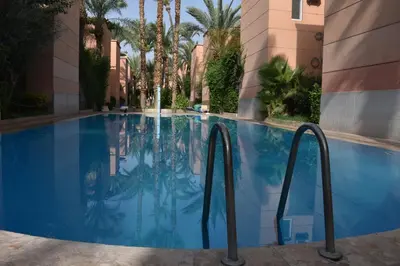 a swimming pool at a hotel with palm trees at Apartment A Zaitone G5 N3 in Marrakech