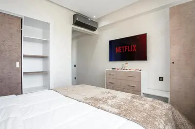 a bedroom with a bed and a tv on the wall at Résidence Coralia, 10 minutes de Guéliz, place Jemaa El Fna in Marrakech