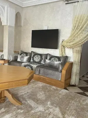 a living room with a couch and a table at Dar Hanane in El Gouassem