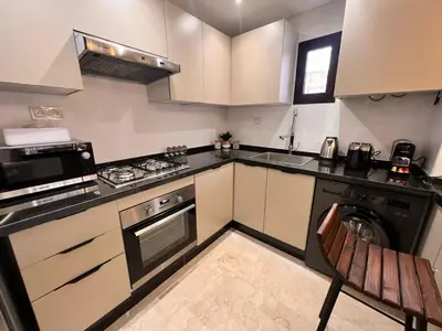 a small kitchen with a stove and a microwave at Appartement Chic avec Terrasse à Gueliz in Marrakech