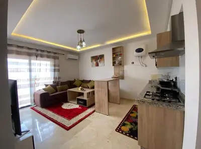 a living room with a couch and a kitchen at LUXURY Apartment Hivernage & Gueliz - Pool, Parking & 24h Security in Marrakech
