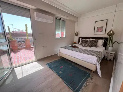 a bedroom with a bed and a large window at Rooftop Terrasse - Centre Gueliz in Marrakech