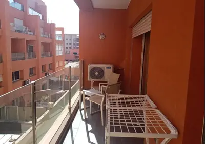an apartment balcony with a bed and a window at Appartement élégant, Escapade parfaite à Marrakech in Marrakech