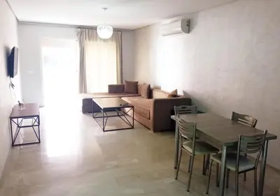 a living room with a couch and a table and chairs at Appartement élégant, Escapade parfaite à Marrakech in Marrakech