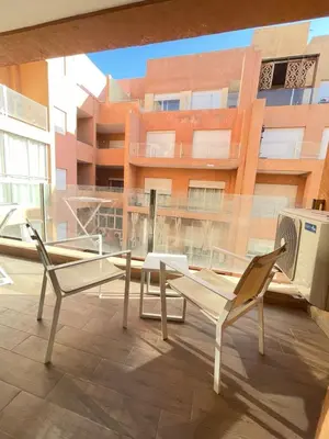 a balcony with two chairs and a table and a building at Appartement élégant, Escapade parfaite à Marrakech in Marrakech