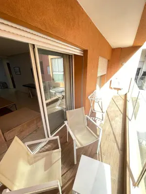 a balcony with chairs and a table and a mirror at Appartement élégant, Escapade parfaite à Marrakech in Marrakech