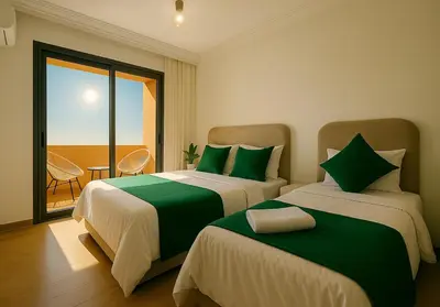 a bedroom with two beds with green and white sheets at Appartement moderne Piscine, Wifi fibre, parking in Marrakech