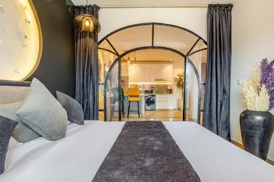 a bedroom with a large bed and a kitchen at LE MAJOREL Centre Marrakech in Marrakech